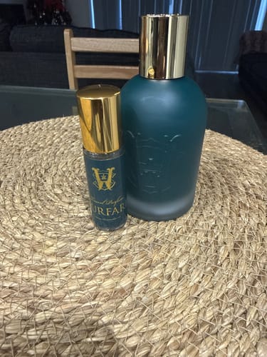 Customer's teal Surfari fragrance bottle and a smaller travel-size version on a woven surface.
