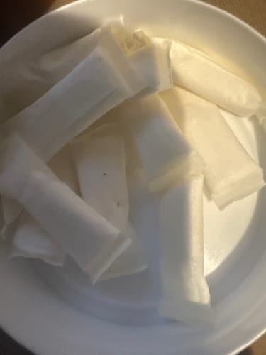 Customer's close-up of Chilled Mint Nicotine Pouches in a bowl. A small, dark speck is visible on one of the white pouches.