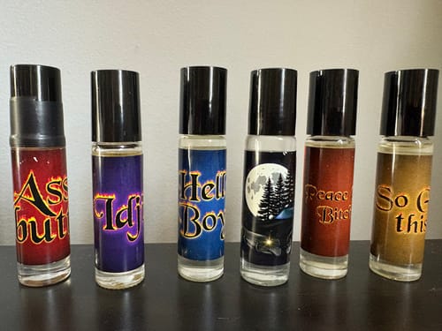 Reviewer's 'So Get This' rollerball perfume shown with five other fragrances from the same collection.