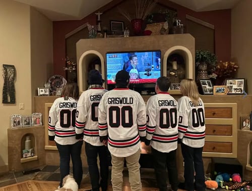 Customers from a family seen from behind, all wearing matching white 'Griswold' 00 hockey jerseys.