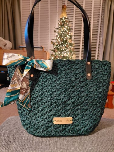 Customer's completed dark green Aveline crochet Shoulder Bag with black leather straps and a decorative scarf.