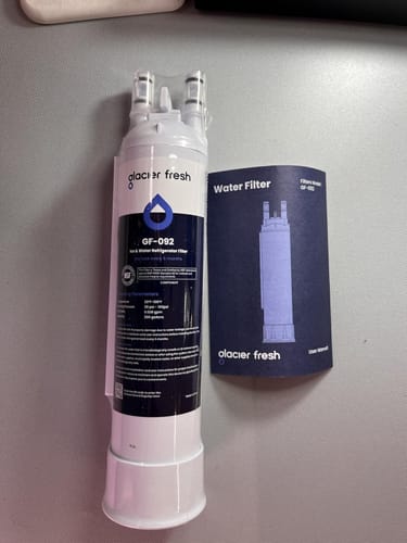 Customer's new GlacierFresh water filter in its packaging, shown next to the user manual on a gray surface.