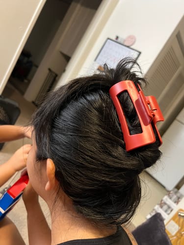 Reviewer's dark hair is held securely in a twisted style by a red cloud clip.
