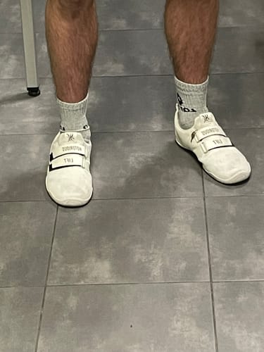 Reviewer wearing the pure white Notorious Lifters Gen 2X shoes, shown from a front-on angle.