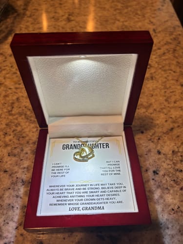 Customer's Forever Linked Hearts gift set in its open mahogany box, with an LED light illuminating the necklace and card.