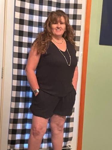 Reviewer wearing the black V-neck short set with hands in pockets.