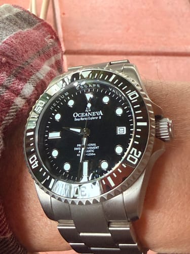 Close-up of the Oceaneva Deep Marine Explorer II titanium watch with a black dial, worn on a reviewer's wrist.