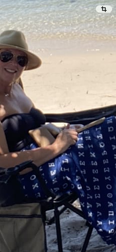 Partial view of a customer at the beach holding a camel accessory from the Ziggy Accessory Bundle in their lap.