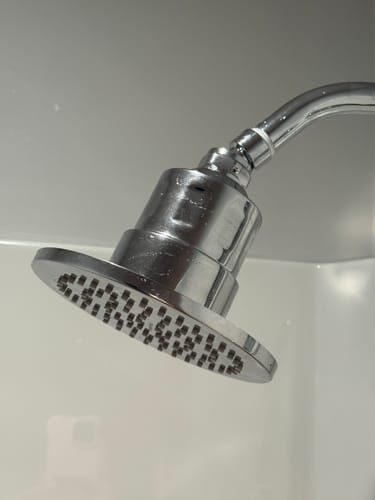 Reviewer's shiny chrome Gillian 6" Filtered Shower Head installed in a shower.