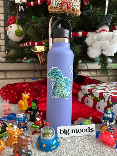 Customer's great lake state sticker on a light purple water bottle in front of a Christmas tree.