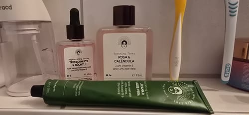 Customer's Barrier Protection Routine products, including a serum, toner, and cream, displayed on a bathroom shelf.