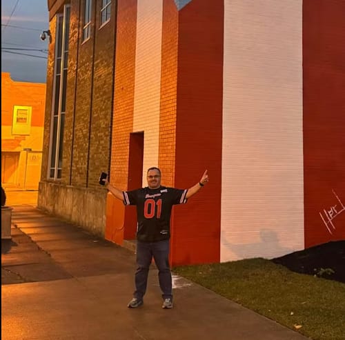 Customer standing outdoors wearing the black Puerto Rico Heritage Custom Football Jersey with red number 01.
