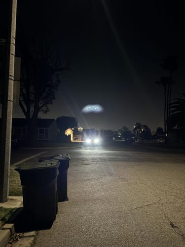 Customer's Super Bright™ LED Car Headlights casting a powerful bright beam down a dark residential street at night.
