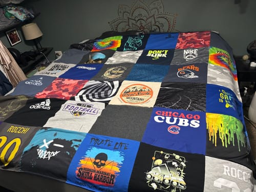 Customer's Premium T Shirt Quilt made of colorful shirts spread out on a large bed.