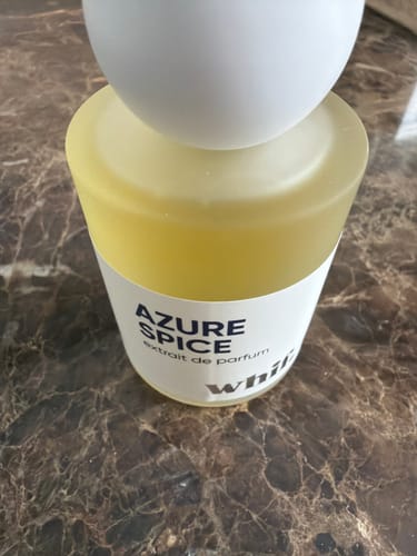 Customer's Azure Spice perfume bottle with a white spherical cap, shown on a marble countertop.