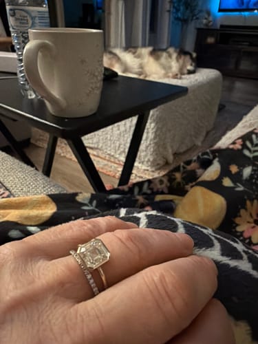 A customer's hand wearing the 3ct Asscher Cut Lab Grown Diamond Bezel Ring stacked with a pave band.