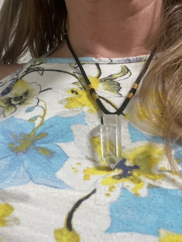 Customer wearing a clear quartz point necklace with a black cord from the VIP Crystal Club.