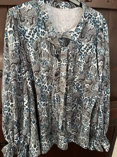 Customer's completed blouse made from the blue and grey animal skin polyester fabric, shown on a hanger.
