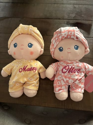 Customer's two Personalized Pudding Baby Girl dolls, one in a yellow outfit named 'Mazzy' and one in a pink outfit named 'Olive'.