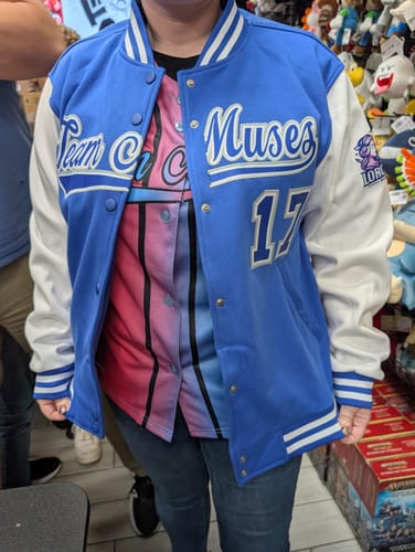 Customer wearing the open custom royal blue and white letterman jacket with 'Team Muses' and '17' on the front.