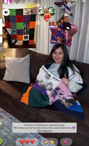 A person sitting on a couch holds a colorful Premium T Shirt Quilt made from sentimental t-shirts.