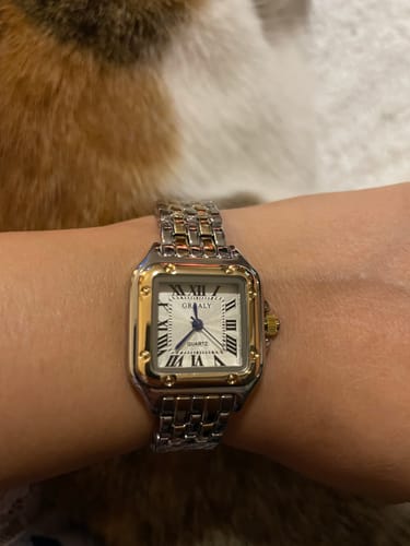 Close-up of the GREALY DE MAINS watch in a two-tone silver and gold finish on a customer's wrist.