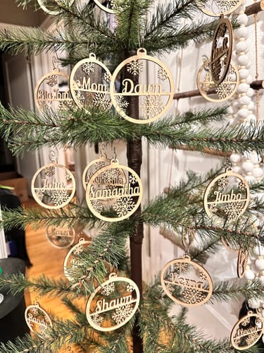 Reviewer's Christmas tree covered in personalized wooden ornaments, creating a 'family tree' with many names.