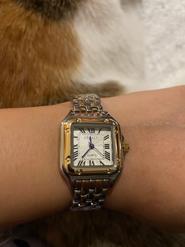 A clear top-down view of the two-tone GREALY DE MAINS watch on a customer's wrist.