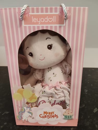 Reviewer's Leyadoll Soft Plush Doll inside the included pink striped gift bag with a "Merry Christmas" sticker.