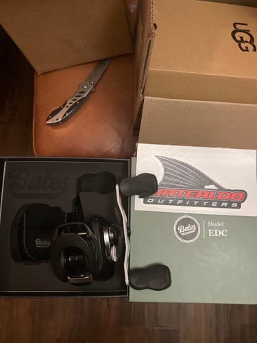 Customer's new Bates E.D.C 100 fishing reel in its open product box with a Waterloo Outfitters sticker.