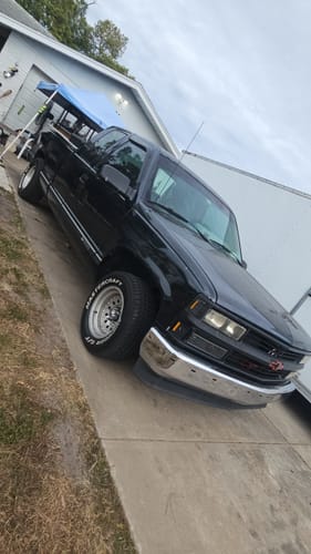 Reviewer's black truck parked in a driveway with the Premium Bullet Antenna installed near the windshield.