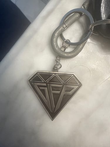 Reviewer's silver Diamond Keychain with a 'GFP' logo, attached to a keyring and carabiner.