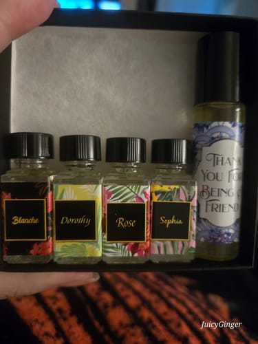 Customer holding the open Thank You for Being a Friend Collection Box showing the five labeled oil bottles inside.
