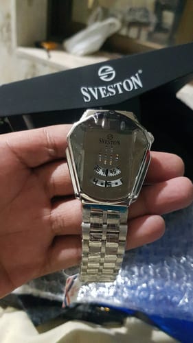 Customer holding the silver stainless steel Ironman watch, with the black Sveston box in the background.