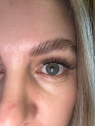 Nahaufnahme vom Auge einer Kundin mit langen Wimpernextensions, die mit dem transparenten DIY SUPER BOND CLEAR befestigt sind.