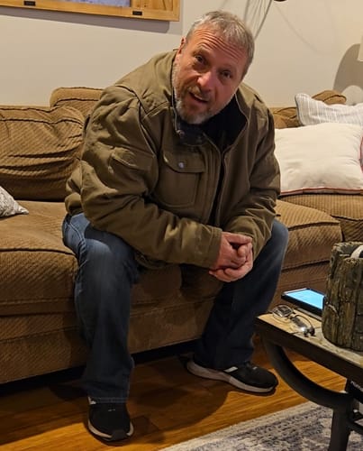 Customer looking emotional on a couch after hearing his custom song from CREATE YOUR MELODY.