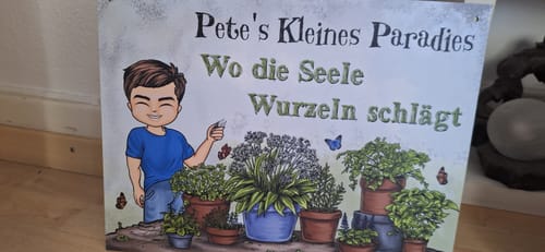 Rezensent zeigt das personalisierte Gartenschild mit einer Zeichentrickfigur und dem Text 'Pete's Kleines Paradies'.