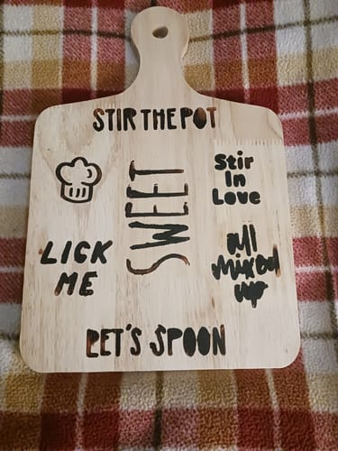 Reviewer's wood burning project on a small cutting board, decorated with several cute cooking-themed words and images.