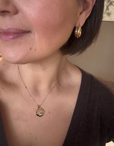 Reviewer wearing the gold-toned Engravable Spinning Necklace with a delicate chain.