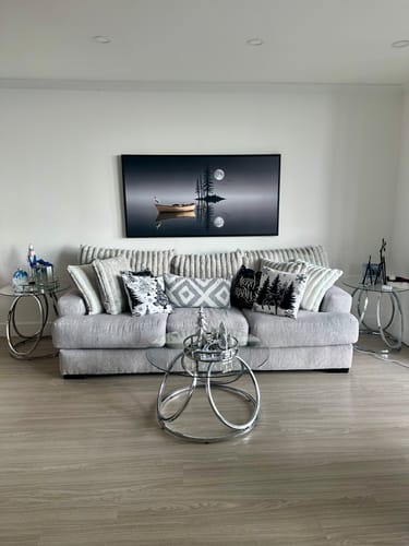 Reviewer's large Tailored Boost canvas with a black frame hanging above a sofa in a living room.
