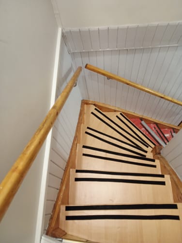 En kundeanmeldelse for Sirocco gulvfliser som viser et bilde av en tretrapp med antiskli-striper.