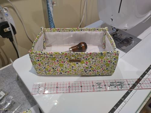 Reviewer's handmade basket sewn from the floral pima cotton fabric, sitting on a desk next to a sewing machine.