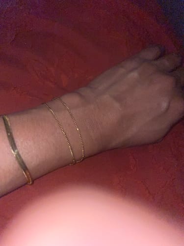 Close-up of a customer's wrist wearing the dainty, gold Double Beaded Bracelet.