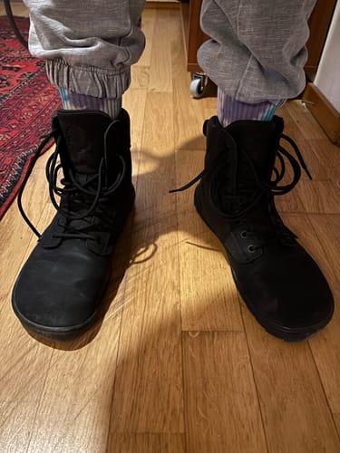 Asiakkaan mustat Vaistoa Hurmos -paljasjalkamaiharit jalassa puulattialla.