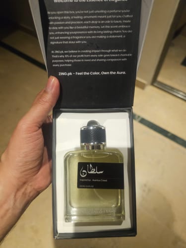 Reviewer holding the open box from the OUD Supreme BUNDLE, revealing a clear glass fragrance bottle inside.