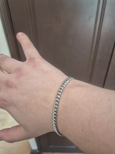 Cliente mostrando la Pulsera Miami Cuban de 5mm en su muñeca en un primer plano.