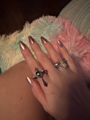 Customer's hand with long metallic nails wearing the Down Your Throat Ring on their middle finger.