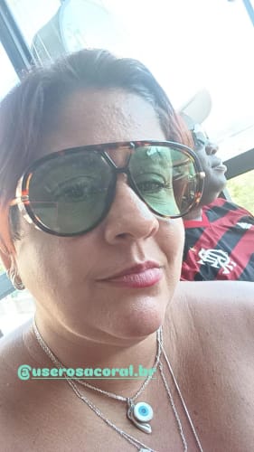 Avaliadora em um close-up, usando os Óculos Tropea com armação tartaruga e lentes verdes.