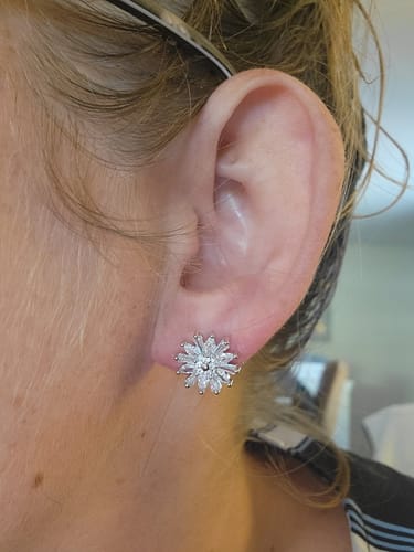 Close-up of a reviewer wearing the sparkling, flower-shaped Astara stud earring.