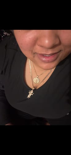 Customer wearing the 14K Divino Niño Pendant with the hollow Cuban curb chain against a black shirt.
